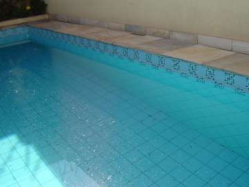 A photo of a swimming pool with a gridded floor and sides. The water is light blue.