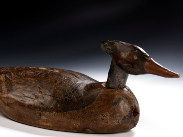 A carved wooden sculpture of a duck.
